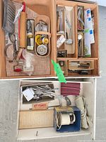 Overall view of both drawers showing majority of utensils, flatware and linens