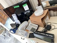 Overview of all electronics on dresser including TV, phone, clocks, accessories