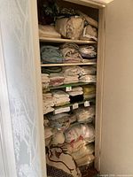 Full closet shelf view showing stacked linens