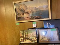 Four framed prints grouped: large Mediterranean coastal landscape top, winter village scene bottom left, B&W portrait top right, color figure print bottom right