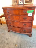 Full frontal view of bowed-front mahogany dresser with four drawers