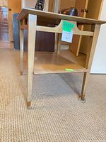 Side view showing overall structure, legs, lower shelf, brass caps