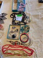 Overall lot view with beaded necklaces, trays of bracelets and bangles