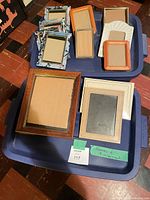 Overview of assorted frames placed on blue Rubbermaid tote lid