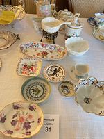 Group view of porcelain bowls, plates, gravy boat, teapot and floral dishes on table