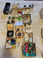 Overall view of lot showing multiple small boxes with earrings, cufflinks, medals, buttons, ribbons