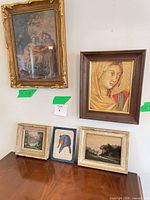 Group shot of all five framed artworks on table and wall