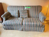 Front view of striped sofa bed with cushions