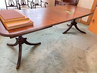 Table fully extended with leaves and protector stacked on top