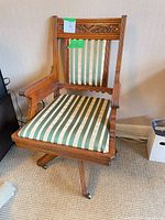 Full front view of chair showing carved back, arms, upholstered seat