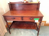 Front view of console table showing overall design, drawers, gallery back, lower shelf