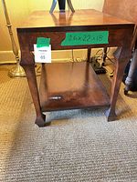 Full frontal view of table showing dimensions tag and lower shelf