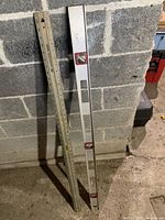 Two 4-ft levels leaning against wall