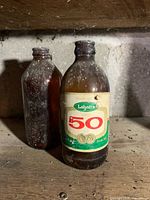 Front view of both stubby beer bottles on shelf