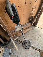 Full view of metal detector leaning against wall