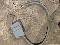 Closed gray Eaton U065P disconnect box with attached flexible conduit whip