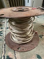 Full view of metal spool with coiled white cable
