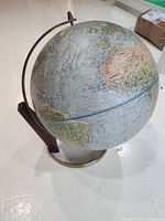 Replogle globe on stand showing overall appearance, metal meridian and wood support visible