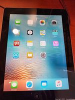 Front view of powered-on iPad displaying home screen apps