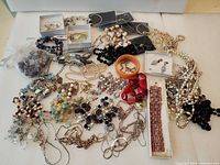 Overall lot with mixed necklaces, bracelets, earrings and rings spread out