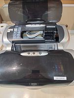 Top view of Epson Stylus C88+ printer with lid open showing cartridge bay and exterior wear