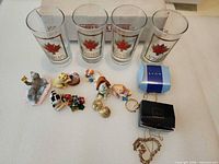Group shot showing four maple leaf tumblers, figurines and Avon jewelry