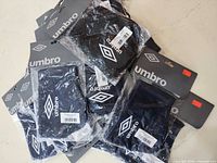 Pile of packaged Umbro headbands displaying logo and hang cards