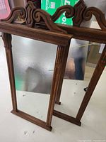 Front view showing both mirrors, carved wood frames and glass surfaces