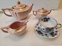 Overall view of teapot, sugar bowl, creamer, teacup and saucer showing colours, trim and condition