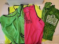 Group of assorted coloured mesh pinnies laid out