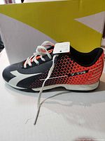 Side view of right shoe showing color scheme, tag, and box
