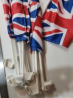 Group of multiple Union Jack car window flags showing folded flags and stacked white plastic mounts