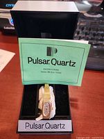 Watch in open Pulsar box with manual visible