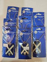 Front view of eight packaged VIVA saltire dog tag necklaces