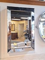 Front view of polished chrome medicine cabinet mounted on wall, mirror door visible