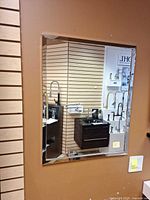 Front view of rectangular wall mirror mounted on display wall