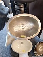 Top view of hammered brushed nickel oval sink showing hammered texture and drain opening