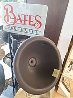 Top view of Bates & Bates round brown cast iron sink with brand sign visible