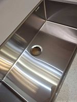 Interior of stainless steel sink showing drain opening and finish