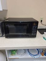 Front view of GE black countertop microwave on counter