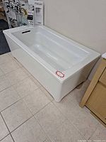 Overall view of Kohler gloss white acrylic bathtub on showroom floor