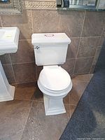 Front view of white Kohler two-piece toilet on showroom floor