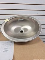 Front view of Kohler stainless steel oval sink on display board
