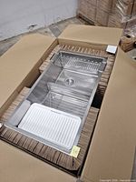 sink in box with wire rack and accessories visible