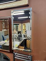 frontal view of mirrored medicine cabinet with chrome trim mounted on wall