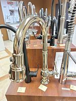 Full view of polished chrome high-arc faucet mounted on display board