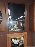 Full view of ginger brown birch medicine cabinet with mirrored door mounted on wall