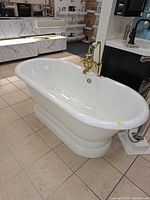 Overall view of white freestanding tub with brass faucet