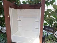 Front view of white fiberglass alcove tub and surround with curtain rod