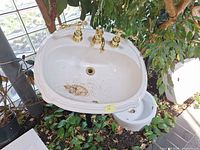 Top view of white porcelain sink with brass faucet, shows overall condition and missing hoses